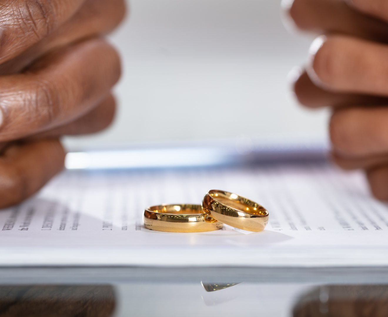 Ehepaar in Scheidung, zwei Hände sichtbar und die Ringe liegen auf dem Tisch